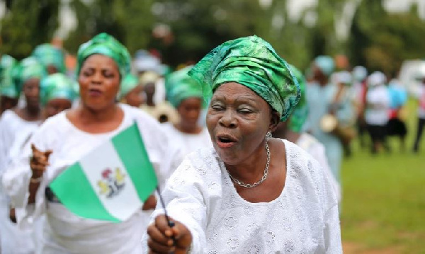 A woman raises the Nigerian flag as she participates in a parade to mark Nigeria's 55th anniversary