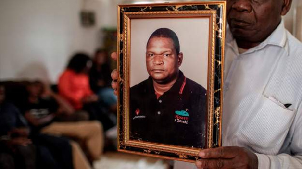 Anastacio Matavele, whose picture is being held by a family member, was killed in October