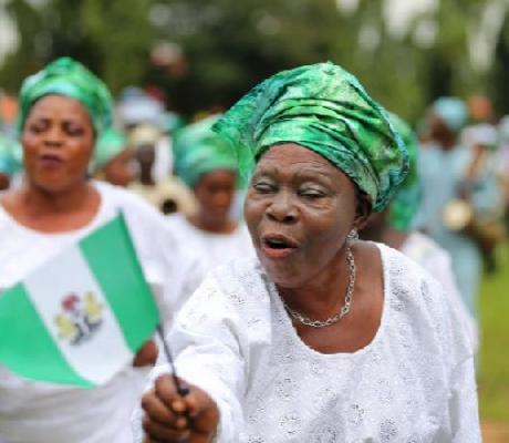 A woman raises the Nigerian flag as she participates in a parade to mark Nigeria's 55th anniversary