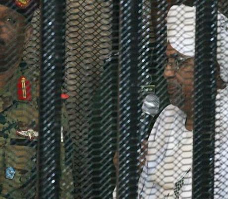Omar al-Bashir appearing in court in a cage