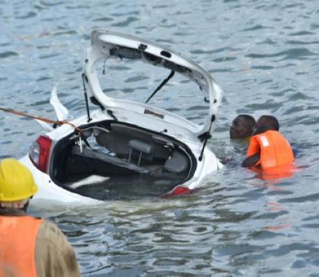 Rescuers retrieve a car from the ocean after it plunged into the Makupa Causeway