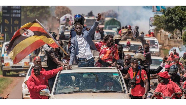 Bobi Wine (centre) greets supporters as he sets off on his campaign trail in Kayunga (AFP)