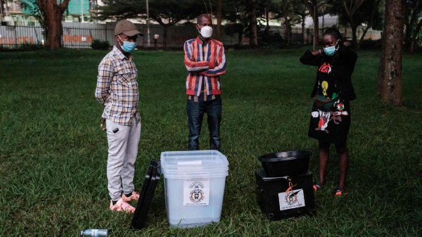 Electoral commission officials wait with ballot boxes at the National theatre in Kampala