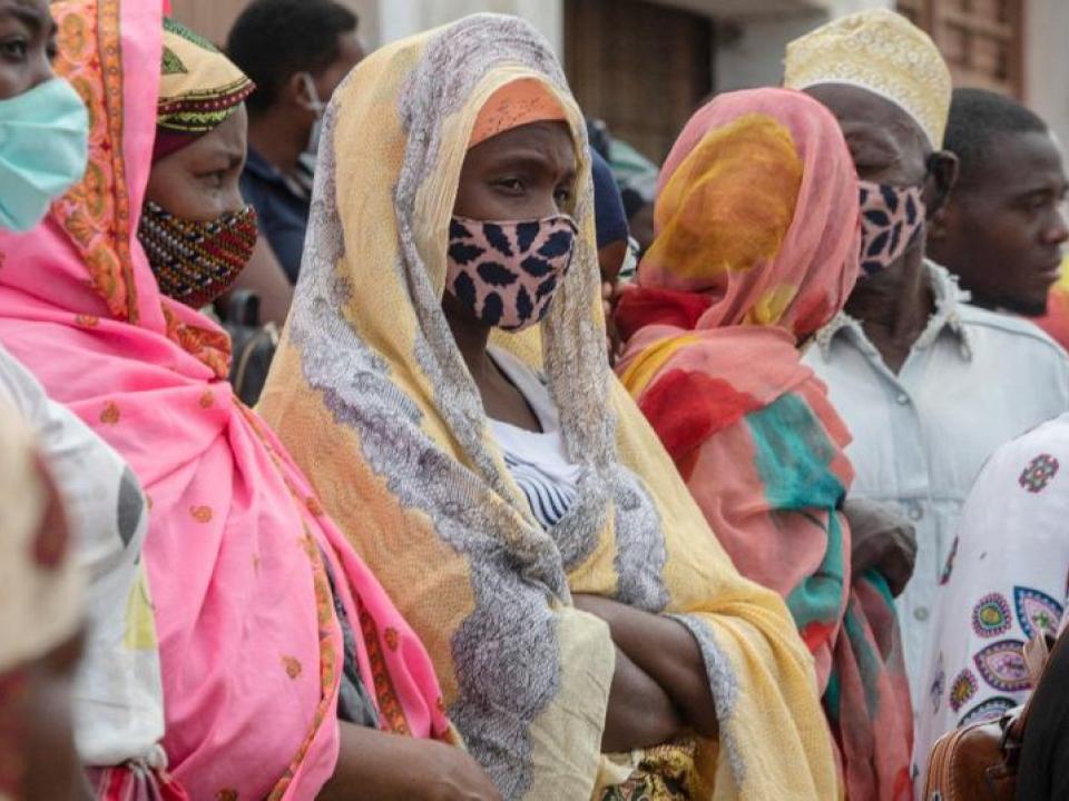 Families wait outside the port of Pemba on April 1, 2021, for the boat of evacuees from the coasts of Palma