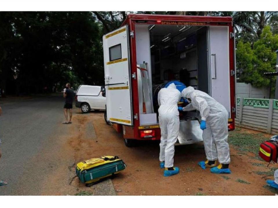 Paramedics put a man with Covid-19 symptoms into an ambulance in Pretoria, South Africa