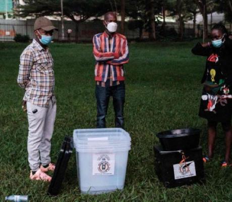Electoral commission officials wait with ballot boxes at the National theatre in Kampala